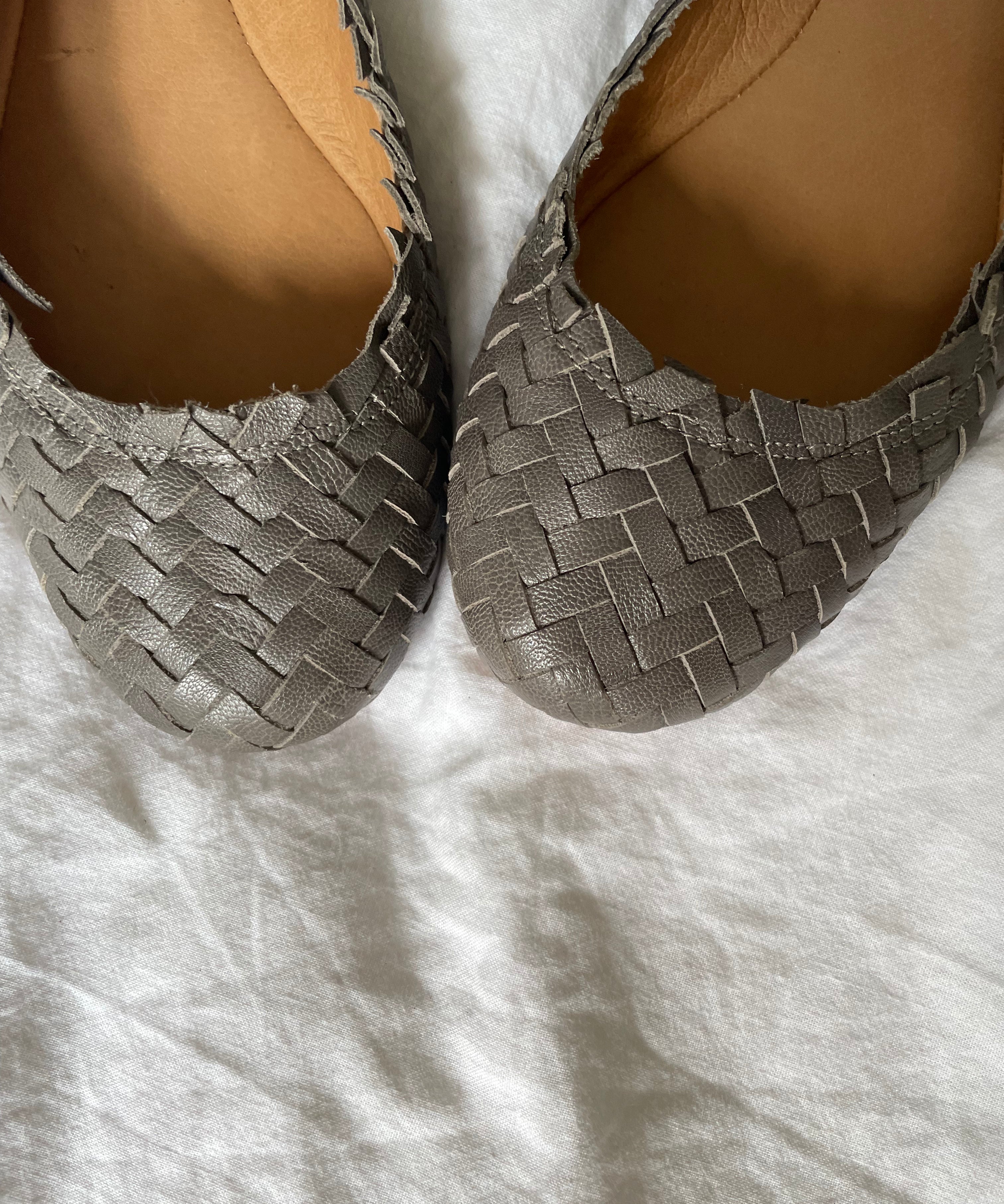 Coach woven leather ballet flats in grey with a subtle silver edge. They’re in excellent condition and show little to no signs of visible wear.